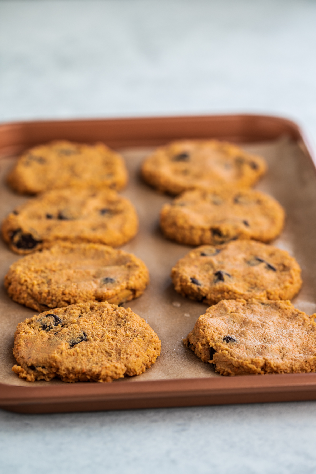 Sweet potato cookies on a baking pan, pressed flat on a baking tray, before going in the oven