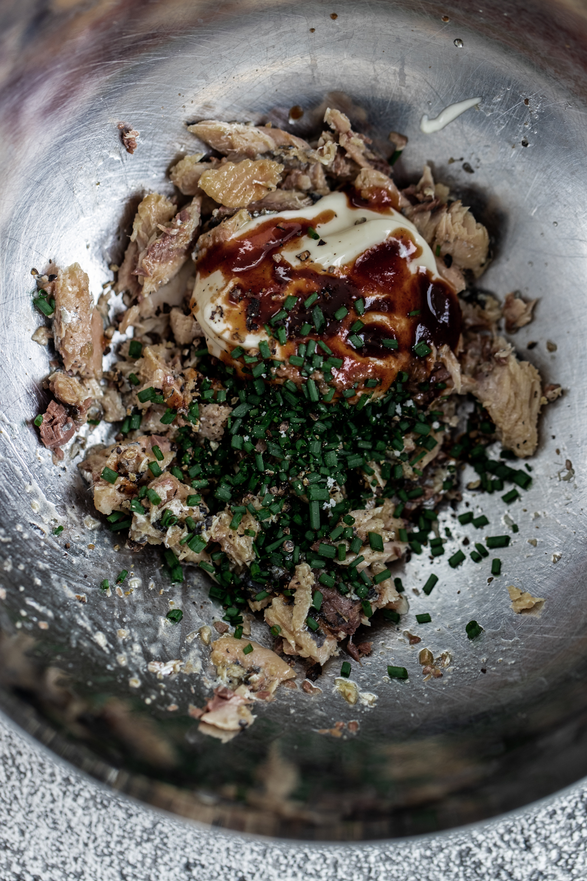 Sardine fillets in a silver bowl with mayo, chipotle and chives