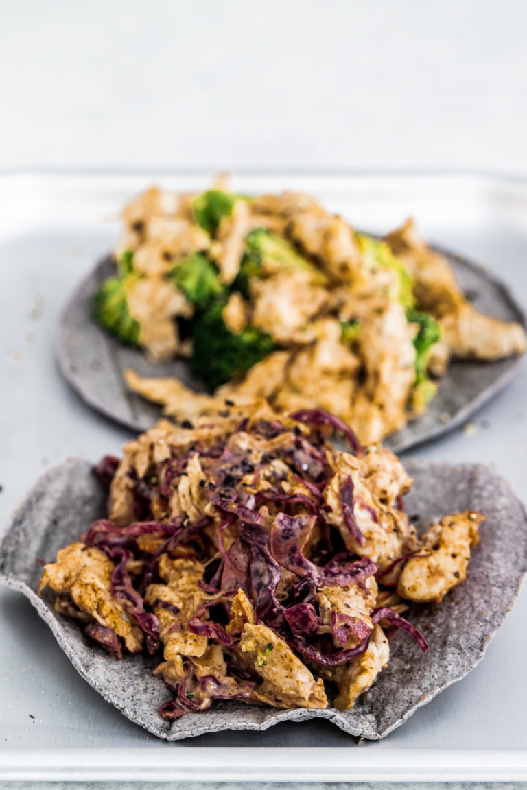 Chicken and pickled cabbage tacos on a silver tray and white background