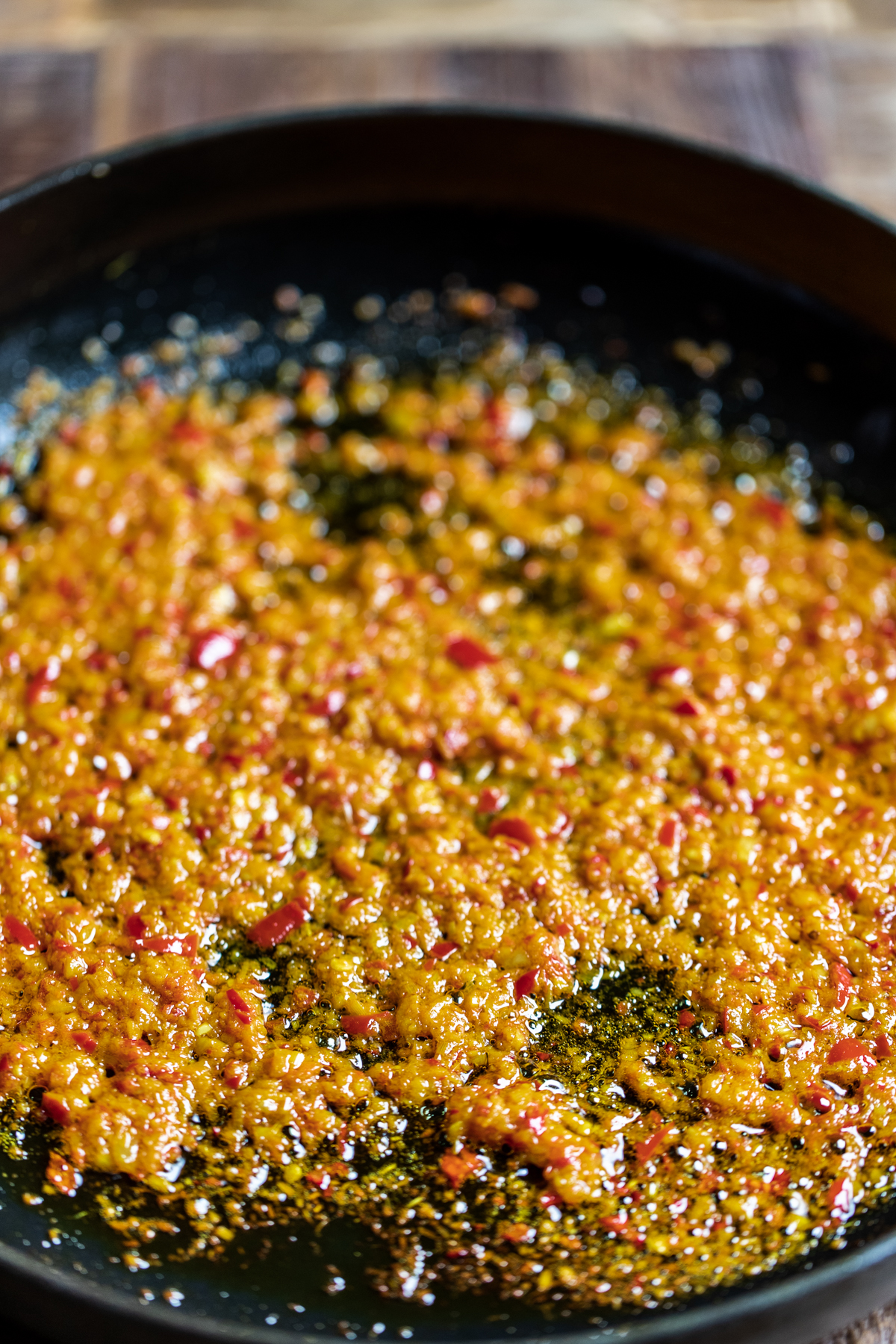 Malaysian curry paste cooking in a black cast iron pan.