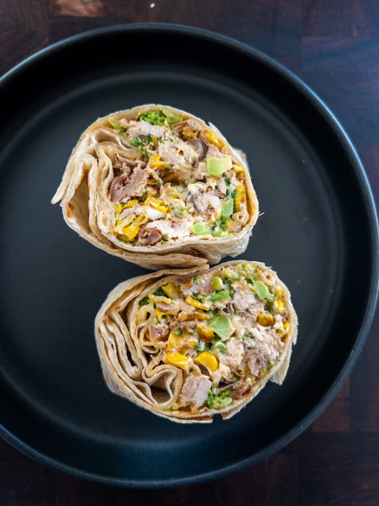 Slow Cooked Chicken, Broccoli & Blackened Corn Burritos on a black plate