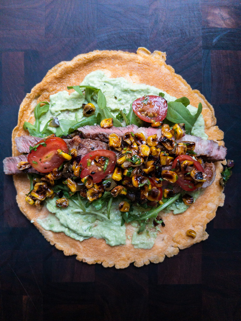 Overhead view of a steak egg wrap on a wooden board