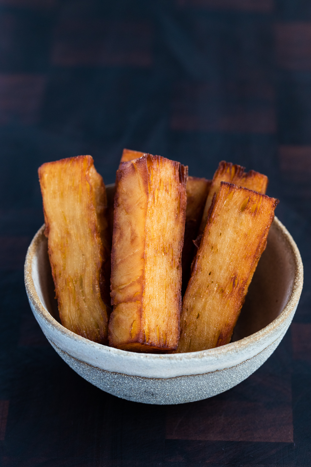 Confit potatoes in a grey bowl on a wooden background