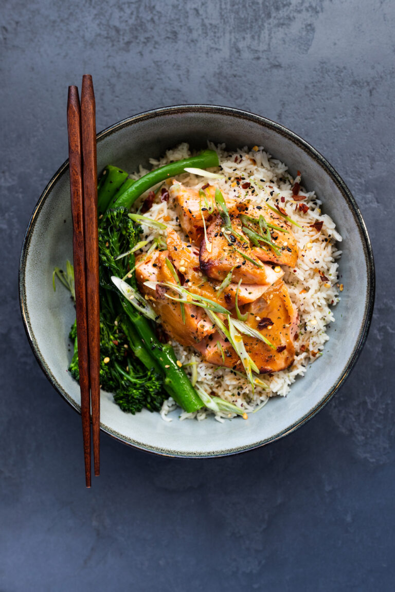 Overhead shot of air fryer miso salmon with rice and tenderstem broccoli in a grey bowl and dark grey background