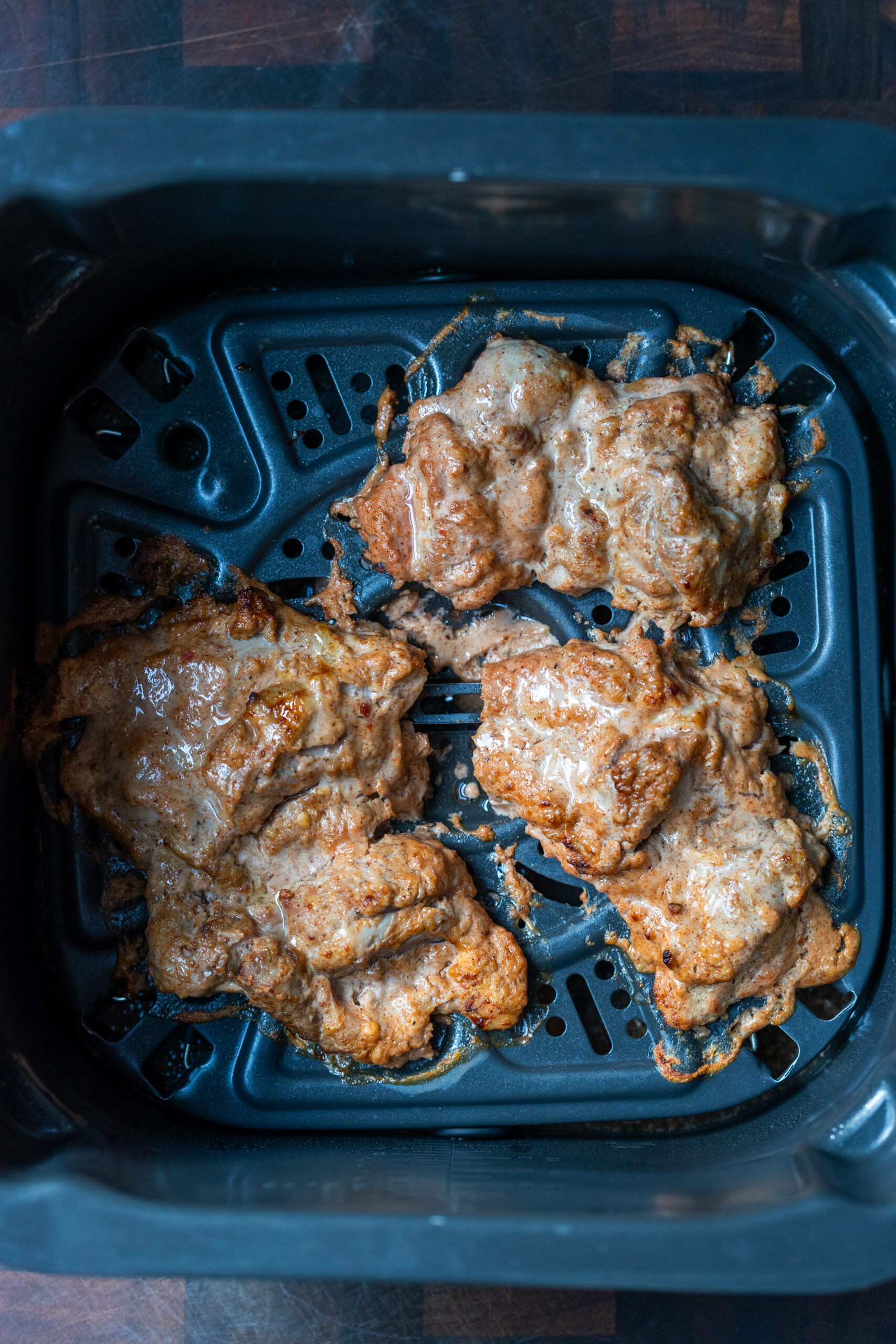 Tandoori chicken in an air fryer, halfway through being air fried.
