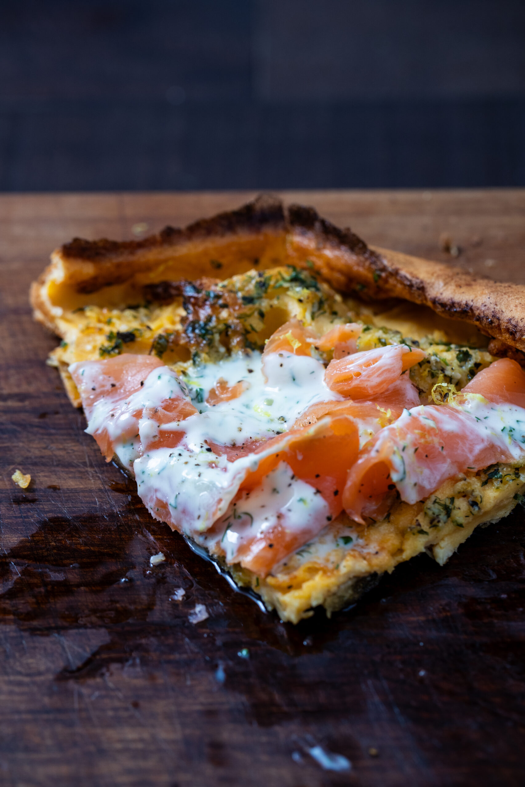 1/4 slice of a savoury dutch baby top with smoked salmon and crème fraîche