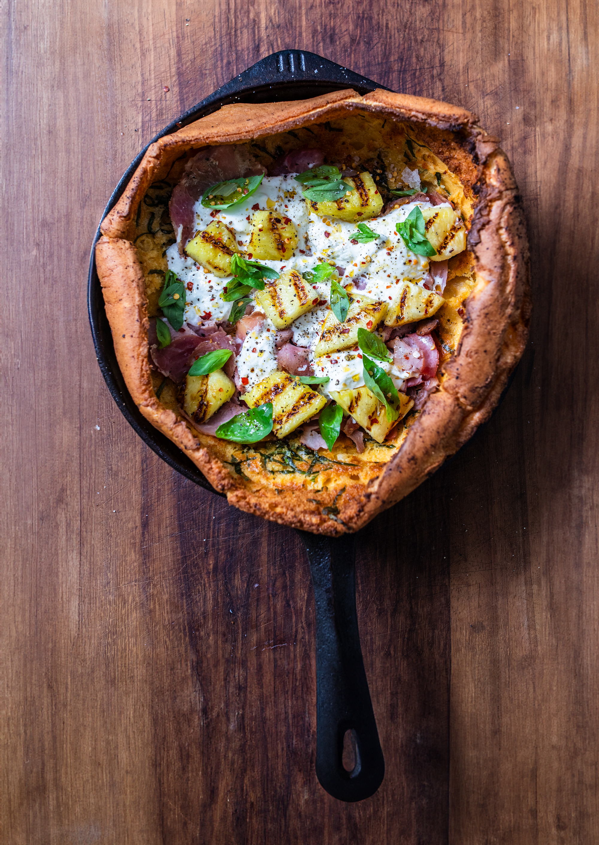 Overhead shot of honey roast ham, burrata and grilled pineapple savoury dutch baby